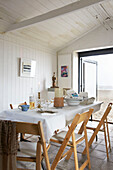 Esstisch mit Klappstühlen in einem Strandhaus in Aldeburgh, Suffolk, England, UK