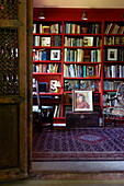 Rotes Bücherregal mit gemustertem Teppich in einem Haus in Massachusetts, Neuengland, USA