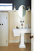 Ovaler Spiegel über einem Sockelbecken im getäfelten Badezimmer des Hauses in Austerlitz, Columbia County, New York, Vereinigte Staaten