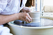 Woman shaping vase on potters wheel, Austerlitz, Columbia County, New York, United States