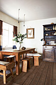 Cut flowers on wooden dining table in Hastings home, East Sussex, England, UK