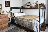 Blau gestrichenes Himmelbett mit besticktem Stoff und Holztruhe in einem Cottage in Hastings, East Sussex, England, UK