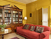 Antique bookcase in yellow panelled drawing room of Georgian townhouse in Laughame, Wales, UK