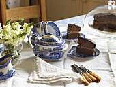 Crockery and chocolate cake on table in city of Bath kitchen Somerset, UK