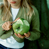 Young girl peeling a cooking apple