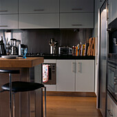 Modern stainless steel and grey painted kitchen with breakfast bar wood floors and plenty of storage space