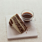 Slice of walnut cake with a cup of black coffee