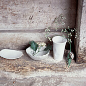 Reihe weißer Haushaltswaren aus Keramik auf einem Steinregal in einem Nebengebäude