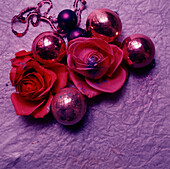 Weihnachtsdekoration mit roten und rosa Blumen und Kugeln