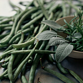 Fresh green beans and a bowl of fresh herbs
