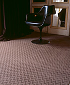 Patterned carpet with vintage retro chair