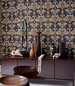 Living room with bold patterned wallpaper and storage unit displaying home wares