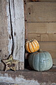 Pumpkins with star shaped ornament in rustic barn interior, United Kingdom