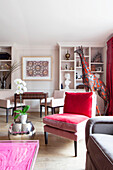 Roter Samtstuhl mit großer Giraffenstatue im Wohnzimmer einer modernen Londoner Wohnung England UK