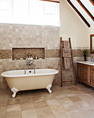 Cream freestanding bath in beamed bathroom of Surrey barn conversion England UK