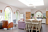 Gewölbte Türöffnungen und Fenster in offener Küche und Wohnzimmer in einem Landhaus in Surrey, England, UK
