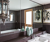 Vintage lanterns above double washbasins in bathroom of Lakes home, England, UK