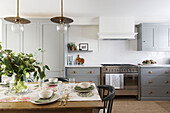 Cut flowers and runner on table in kitchen of London home UK