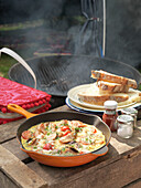 Full English breakfast in frying pan with bread and barbecue grill England UK