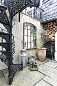 Black wrought iron metal staircase in courtyard of Winchester home UK