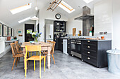 Wooden table and chairs with black fitted kitchen in spacious open plan Reading kitchen Berkshire England UK