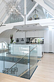 Offene Küche mit polierten Betonoberflächen und Glasgeländer in einem umgebauten Gerichtsgebäude in London UK