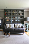 Graues Sofa und Bücherregal im Wohnzimmer eines Stadthauses in Guildford, Surrey UK