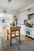 Spring bulbs on butchers block in kitchen of Guildford cottage Surrey UK