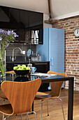 Exposed brick wall in modern dining and kitchen area