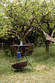 Hurricane lamp with reflector and garden furniture in long grass East Sussex