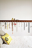 Wooden jewellery rail and bed with yellow cushion