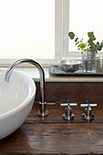 Mixer tap and sink with silverware in bathroom of London home England UK
