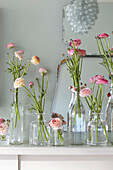 Cut flowers in glassware on shelf in Scottish apartment building UK