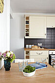 Salad and cut flowers with wine storage in contemporary Weymouth beach house, Dorset, UK