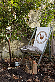 Liegestuhl und Spaten mit Werkzeugset im ummauerten Garten, St Lawrence, Isle of Wight, UK