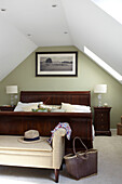 Antique wooden bed in attic conversion of Bembridge beach house, Isle of Wight, England, UK