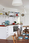 Kitchenware in retro style Bembridge home with wooden table and chairs, Isle of Wight, UK