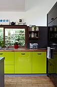 Lime green cupboards in fitted kitchen of contemporary new-build Isle of Wight home