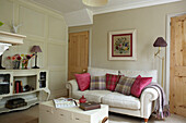 Rosa und karierte Kissen auf dem Sofa im Wohnzimmer mit bemalter Anrichte, Haus in East Cowes, Isle of Wight, Vereinigtes Königreich
