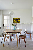 1960s style dining table with chairs and mustard sign in Ryde kitchen Isle of Wight, UK