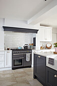 Range oven with flagstone flooring and Shaker style units in Buckinghamshire kitchen UK
