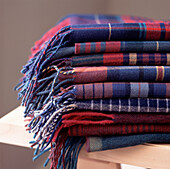 Pile of Tartan wool rugs on a table