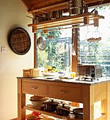 Moderne Landhausküche mit freistehender Holzwerkbank und Pfannenständer