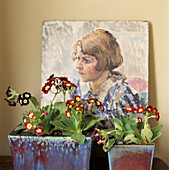 Auriculars in einem quadratischen glasierten Topf vor einem Ölgemälde eines jungen Mädchens