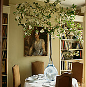 Dramatische Glasvase mit einem Zweig von Burkwood Viburnum auf dem Esstisch