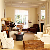 Wohnzimmer mit cremefarbenem Dekor und passenden Möbeln und Blick auf den Wintergarten