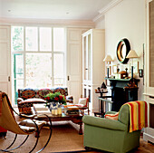 Living room with bright green armchair and low ethnic coffee table by a sunny French window