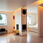 Modernes, offenes Schlafzimmer mit zentralem Kamin mit Blattvergoldung