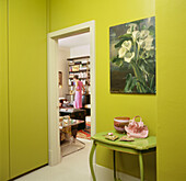 View of woman through doorway into living room from a striking vibrant green decorated hallway