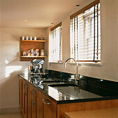 Küchenspüle am Fenster mit schwarzer Granitarbeitsplatte und Kirschholzschränken